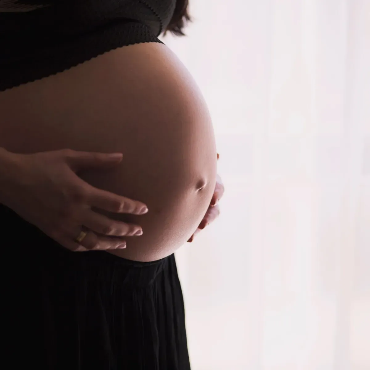 Schwangere hält mit beiden Händen ihren Babybauch